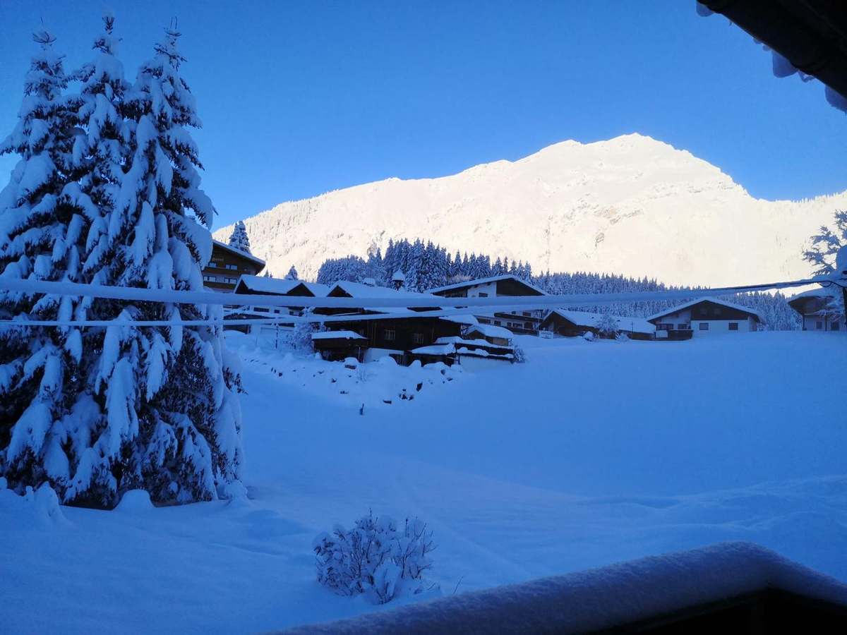Winterliche Aussicht vom Haus auf den Berg im Morgenlicht