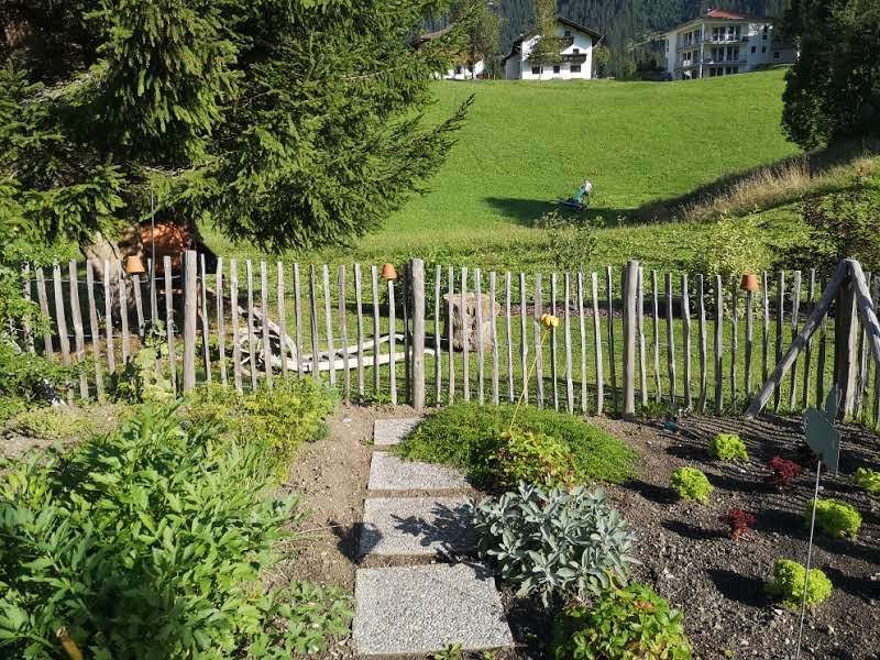 Holzzaun und Steinplatten-Weg im Garten des Haus Resi